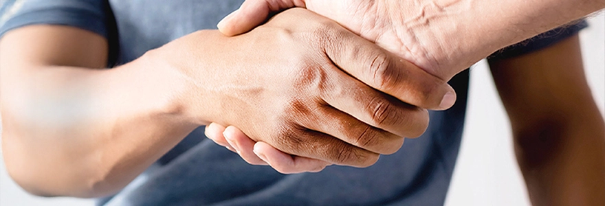 Dr Lincoln Tan shaking hands with a patient after a urology consultation in Singapore.